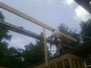 Carpenter setting a ridge beam over a new addition frame — Ice Dam Removal by Roofing Brothers in Glen Saint Mary