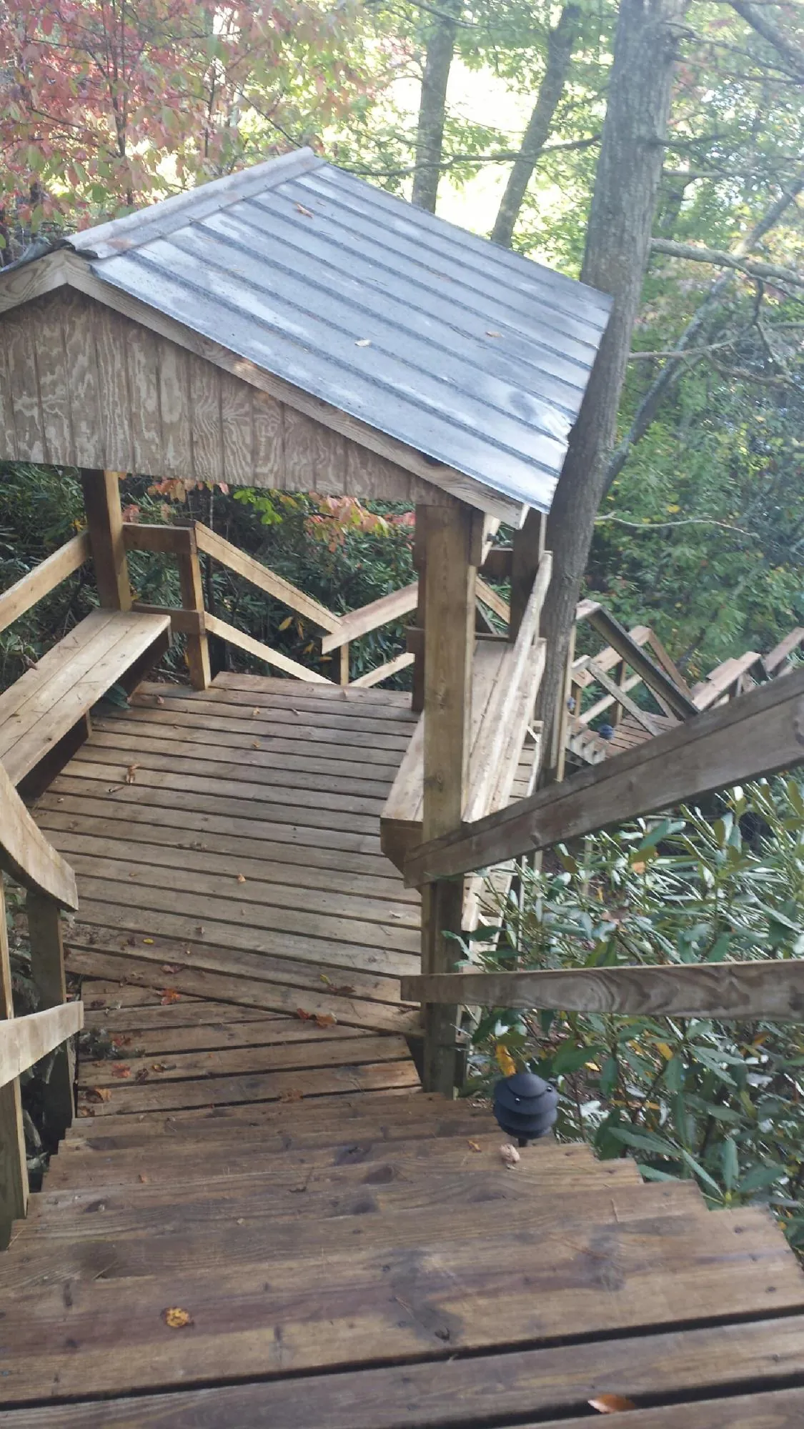 Metal roofed shelter over wooden steps on a wooded walkway — Skylight Repair & Installation work by our crew in Glen Saint Mary